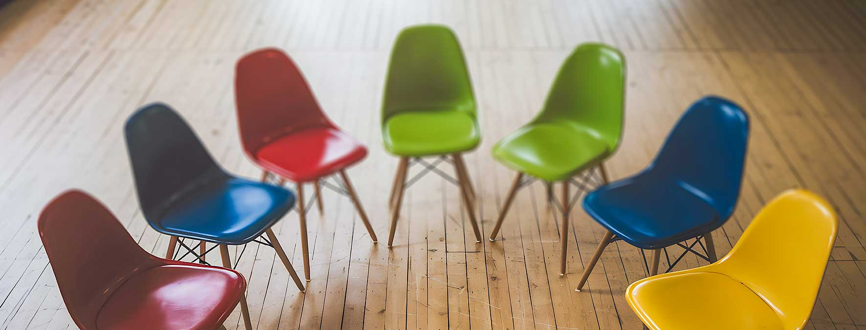 Bunte Stühle stehen in einem Halbrund für ein Seminar