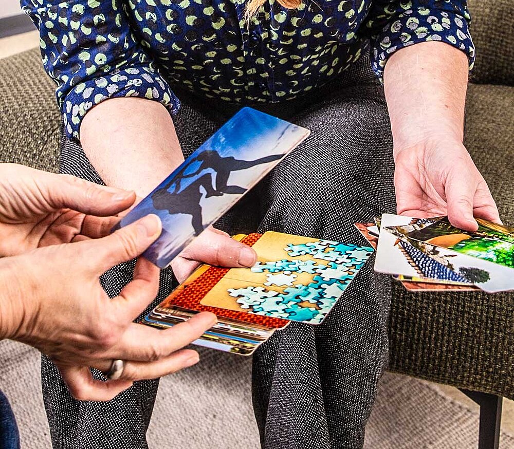 Hände suchen Katrn aus mit verschiedenen Bildern und Symbolen
